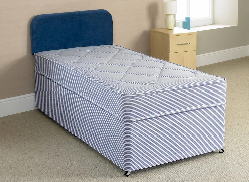 A divan bed set with pale blue mattress and dark blue headboard.